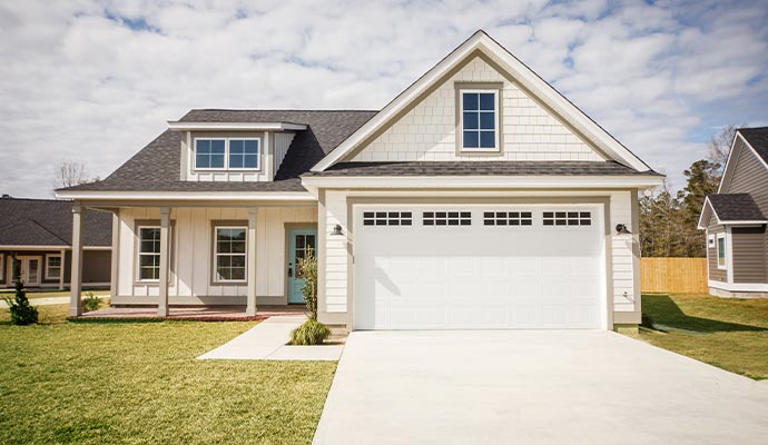 Front view of a white raised panel garage door on a residential exterior