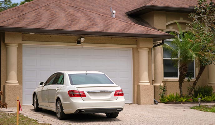 Car parked in front of a residential garage with closed garage door