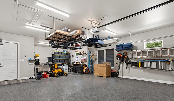 Organized garage with hanging storage shelves, tools, and equipment