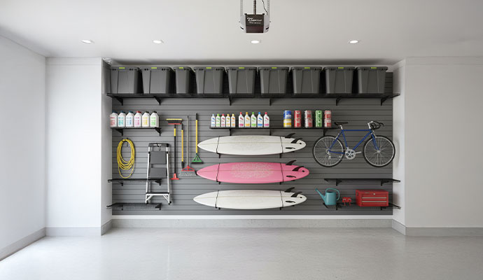 Modern garage with a slat wall storage system featuring shelves and hooks holding multiple equipment