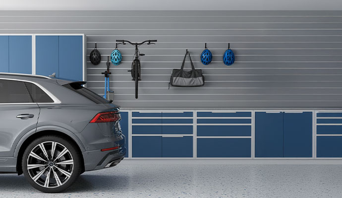 Modern garage with blue cabinets and a slat wall system designed for bike and helmet storage