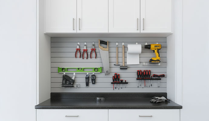 Organized garage workbench with a slat wall system for hand tools, drills and small equipment