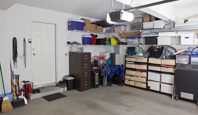 Well organized garage with ceiling storage racks, wall shelves, and neatly arranged tools