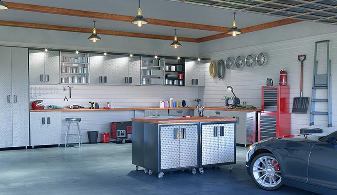 Modern garage featuring metal cabinets, a workbench, wall-mounted tools and a parked car